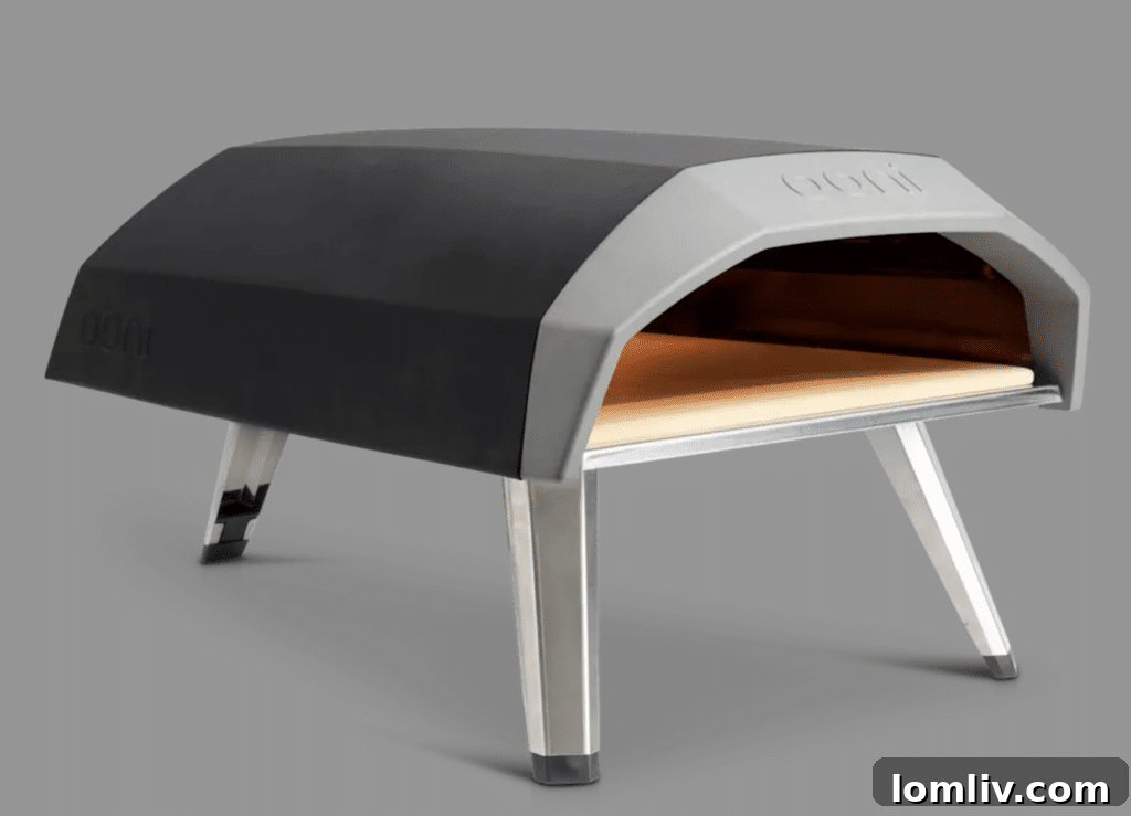 The Ultimate Holiday Gift Guide 11 A compact and stylish Ooni Koda Pizza Oven, set up for outdoor use and ready to bake delicious pizzas.