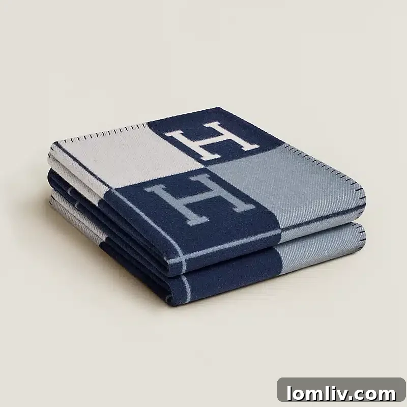 The Ultimate Holiday Gift Guide 3 The iconic Hermès Avalon III Throw Blanket in a sophisticated neutral color, showcasing its woven wool and cashmere texture.