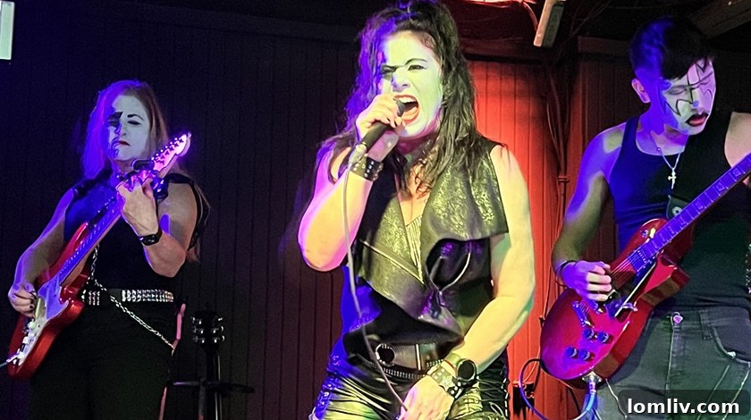 Janelle Alcantara singing and drumming on stage