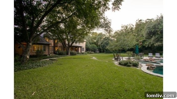 Staged backyard of the 5433 Falls Road estate, featuring lush landscaping and ample entertaining space