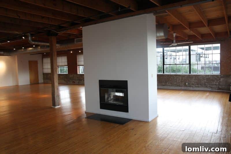 Double-sided fireplace dividing living spaces in loft unit 317