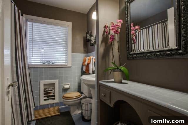 Vintage tiled bathroom at 2531 W 10th Street with blue shades of tile and taupe painted walls