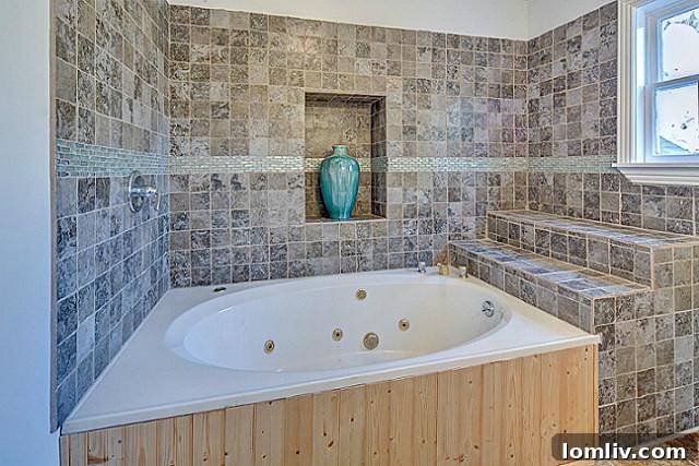 Luxuriously remodeled master bathroom with jetted tub and elegant tile work at 9003 Groveland