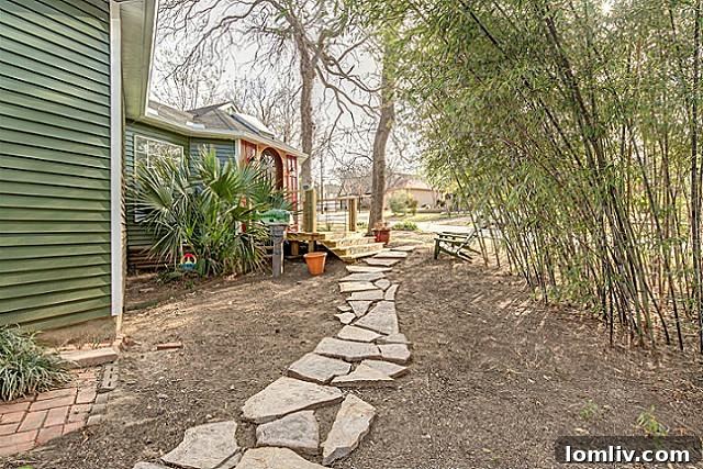 Charming pathway leading to the entrance of 9003 Groveland, surrounded by mature landscaping