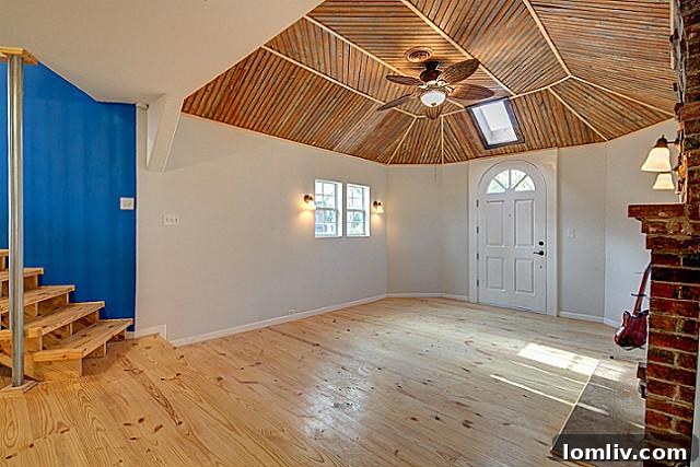 Bright and airy living room with exposed beam ceilings and large windows at 9003 Groveland