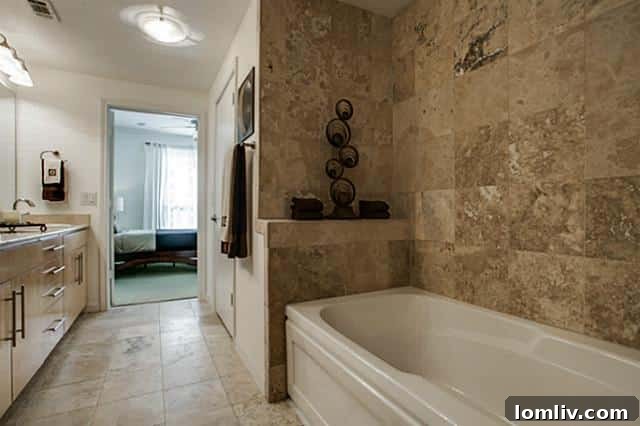 Luxurious bathroom with jetted tub, elegant tile, and spacious vanity