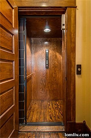 Interior view of a modern elevator installed within the historic 2113 Mangum home, featuring a classic paneling facade that seamlessly blends convenience with the classic architecture.