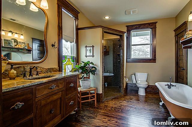 Elegant master bathroom at 2113 Mangum, showcasing a harmonious blend of modern amenities like a free-standing glass shower and a classic antique claw-foot tub, surrounded by refined finishes.