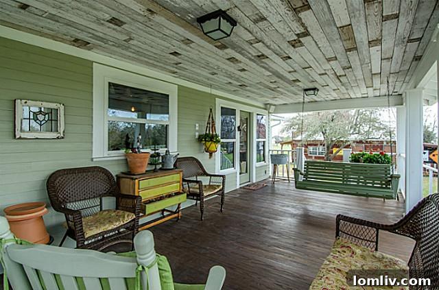 Close-up view of the welcoming front porch at 2113 Mangum, showcasing intricate architectural details, a patterned ceiling, and ample space for relaxation, epitomizing historic charm.