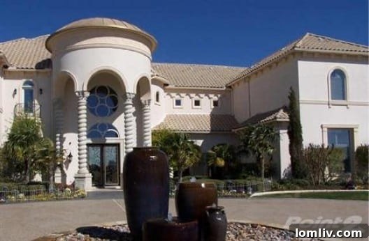 Exterior view of a luxury home, possibly Deion Sanders' new residence in Lake Ridge, featuring elegant landscaping.