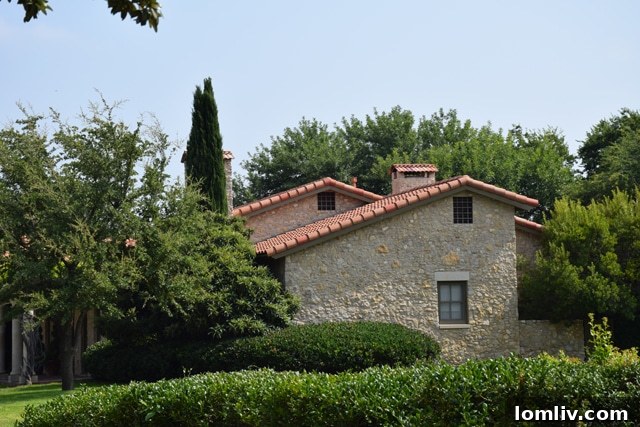 The exquisite exterior of Jane McGarry's former Fort Worth home, featuring rubble stone, mortar, and a beautiful terracotta tile roof.