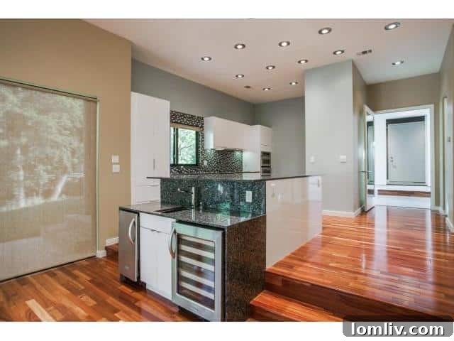 Kitchen island with built-in wine fridge and bar seating in a luxury Dallas home