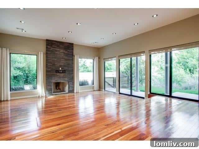 Elegant living area featuring a fireplace, hardwood floors, and abundant natural light