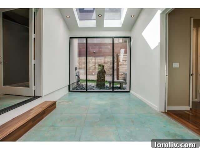 Glass-enclosed breezeway with gorgeous stone tile floor connecting home sections