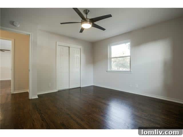 Bedroom with original hardwood floors, new ceiling fan, and ample natural light
