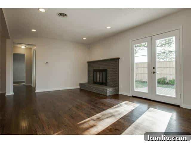 Bright and spacious living area of the renovated home with hardwood floors