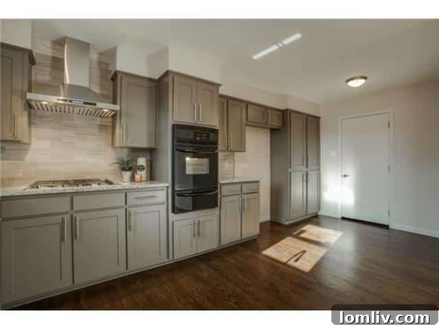Modern black and stainless steel appliances in the kitchen, including gas cooktop and vent hood