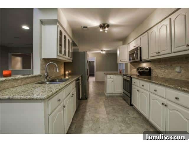 Modern kitchen with granite countertops and stainless steel appliances at 13016 Fall Manor