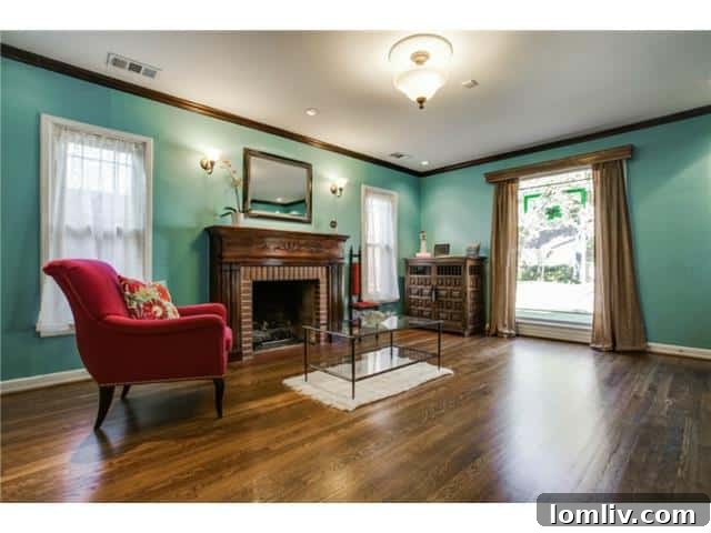 Cozy living room with a prominent brick fireplace and elegant mantle, featuring a serene blue-green wall color at 5027 Bradford Drive
