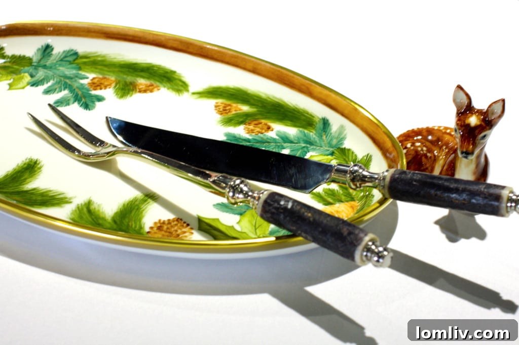 Elegant forged carving set with horn handles next to a beautiful hand-painted ceramic plate featuring a deer motif, ideal for holiday dining