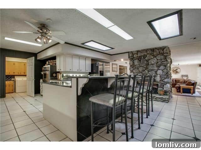 Seeking East Dallas Midcentury Original Hardwoods This Christmas 10 Spacious open-plan living area with an angular stone fireplace and high ceilings at 9364 Forest Hills Blvd