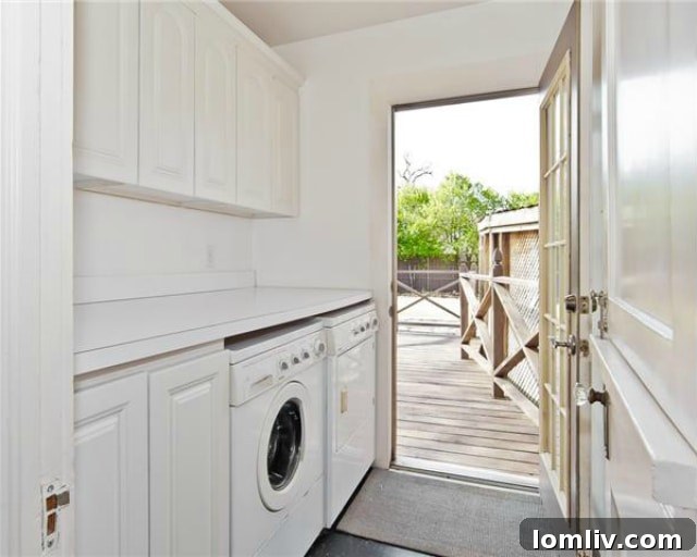 Historic North Oak Cliff Tudor: Stained Glass and Chambers Stove Legacy 12 Functional laundry room with modern built-in cabinets and counter space, suitable for full-size appliances
