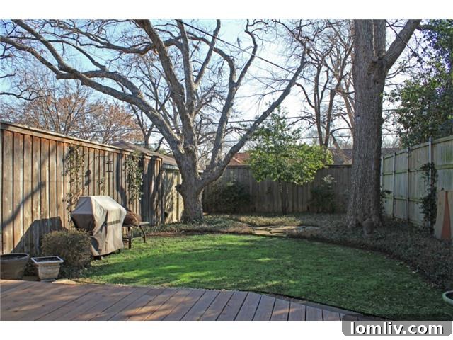 Lush Fenced Backyard of Tudor Home with Mature Trees