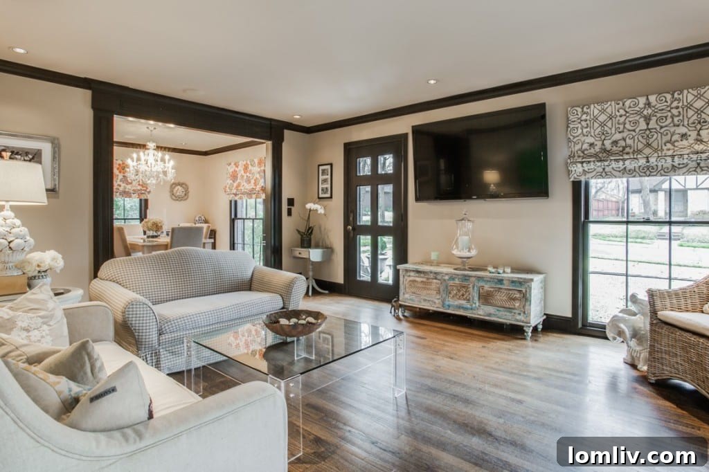 A bright and airy dining area with hardwood floors and elegant window treatments, leading into another living space.