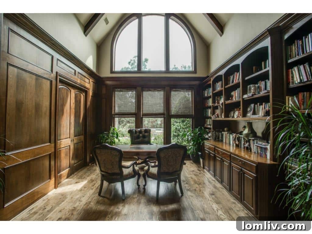 An elegant study at 4436 Brookview, featuring rich wood paneling, a two-story ceiling, and sophisticated built-in computer workstations.