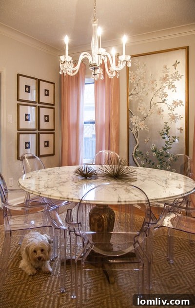 Modern 'Ghost' chairs elegantly paired with a vintage marble-topped table and crystal chandelier, creating a striking visual contrast in the dining room of Emily Larkin's home.