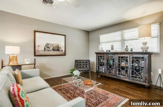 Another perspective of the living room highlighting the hardwood floors and natural light