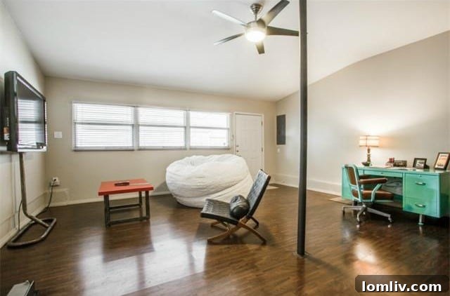 Second living area with gleaming hardwood floors and ample natural light