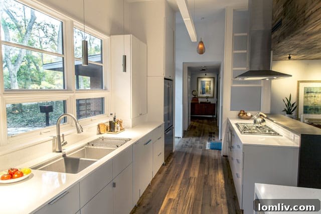 Renovated kitchen with new cabinetry and industrial venthood in Studio Perk's Sylvania home.