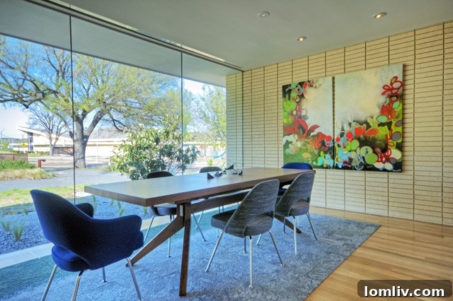 Floor-to-ceiling glass windows connect the dining and living room to the outdoors in a Cliff Welch modern home.
