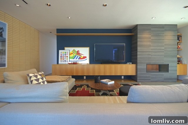 Den with continuous fireplace and cabinetry design, reflecting clean lines in a modern home.