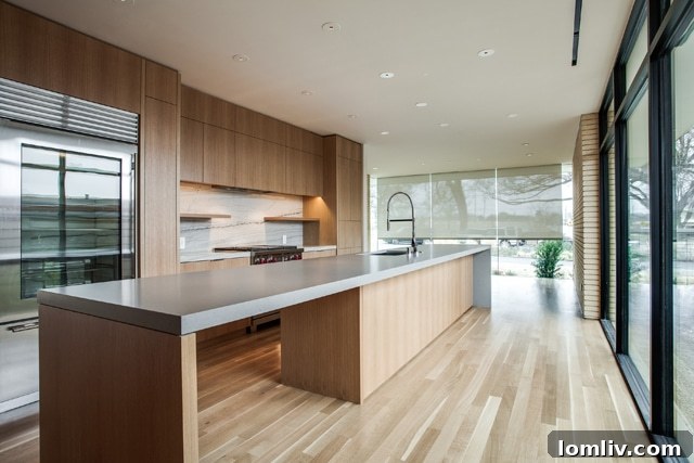 Modern kitchen with lengthwise hardwood floors, large eat-in island, and ample cabinetry.