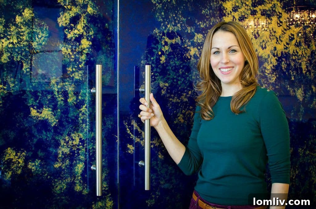 Jennifer Ayyad showcasing her artistry with two large-scale acrylic doors she painted for Nathan Grace Real Estate's Frisco office.