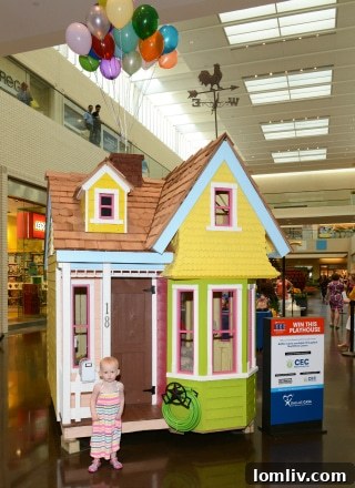 A unique, architecturally designed playhouse on display at the Dallas CASA Parade of Playhouses, viewed from an angle.