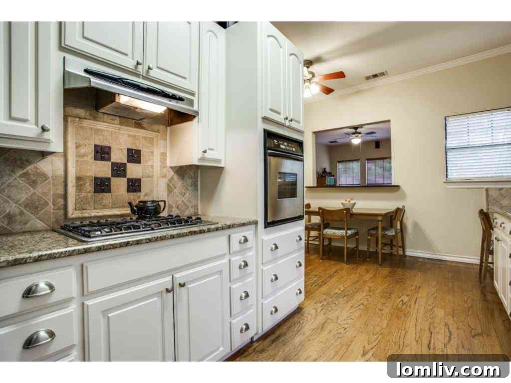 Close-up of the pristine kitchen showing granite details and appliance placement.