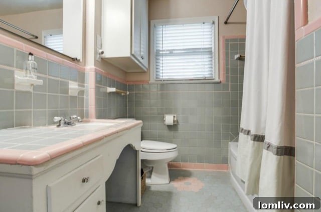 Tastefully renovated bathroom preserving original pink-and-gray tiles