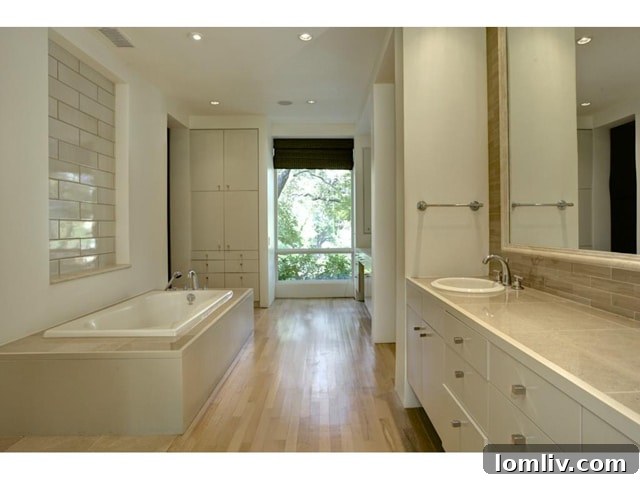 Luxurious master bathroom featuring a soaking tub, separate shower, and elegant stone finishes.