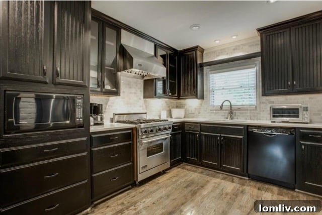 Gourmet kitchen with stainless steel Viking range, espresso cabinets, and marble subway tile at 5824 Palm Ln