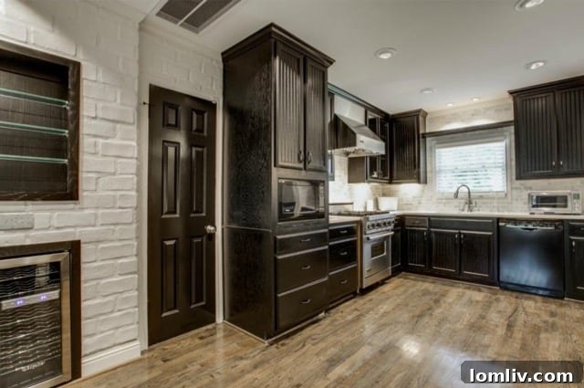 Modern kitchen featuring a marble subway tile backsplash, wine refrigerator, and white-painted brick wall at 5824 Palm Ln