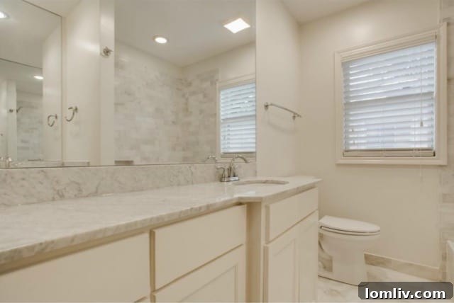 Elegant master bathroom with pristine marble tile, modern fixtures, and spacious shower at 5824 Palm Ln