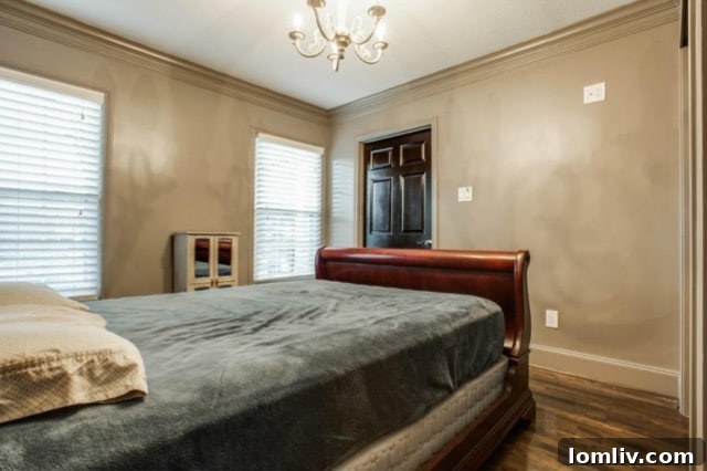 Second well-appointed bedroom with hardwood floors and elegant crown molding, suitable for guests or family at 5824 Palm Ln