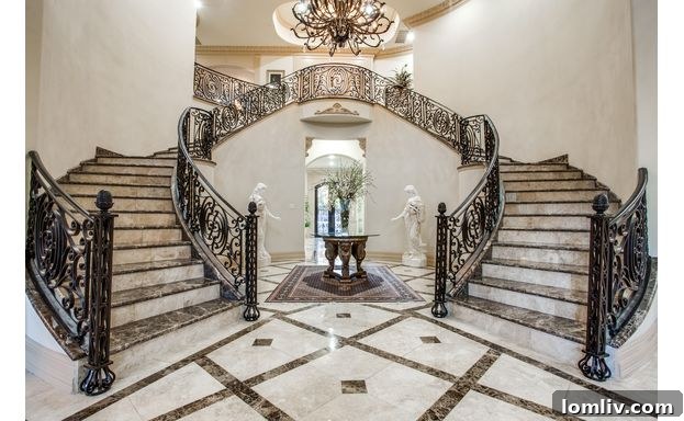 Grand staircase inside the 6326 Lakehurst Mediterranean mansion, showcasing intricate details and luxurious finishes.