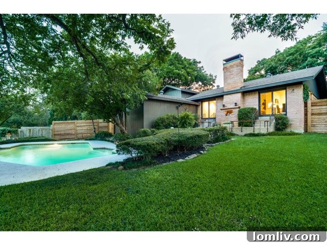 A wider view of the backyard, highlighting the lush greenery and spacious design.