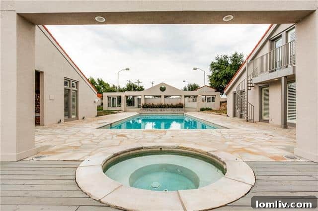 Long shot view of the expansive pool area, lush landscaping, and tranquil lakefront
