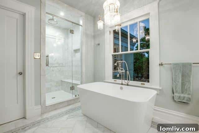 Spacious master bathroom with double vanity, elegant lighting, and modern fixtures