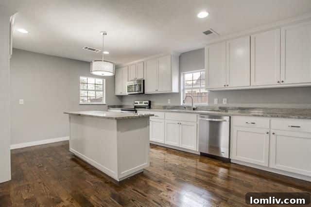 The magnificent modern kitchen after renovation, featuring stainless steel appliances, a large island, and contemporary design elements.